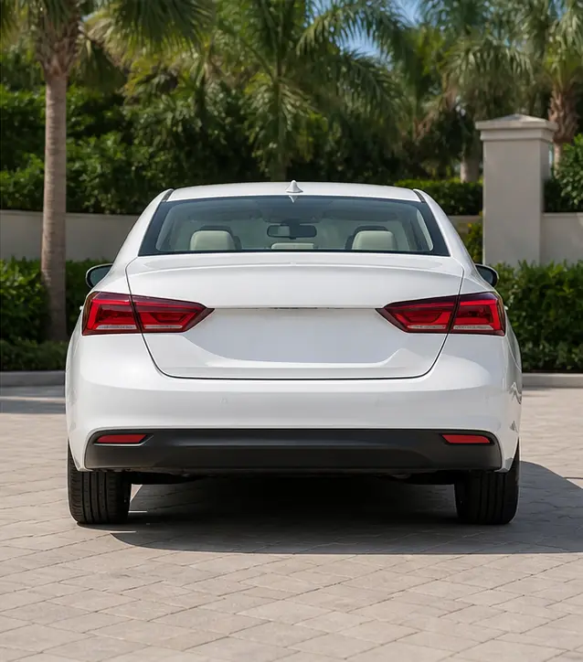 Pearl White sedan shown from the rear during the day